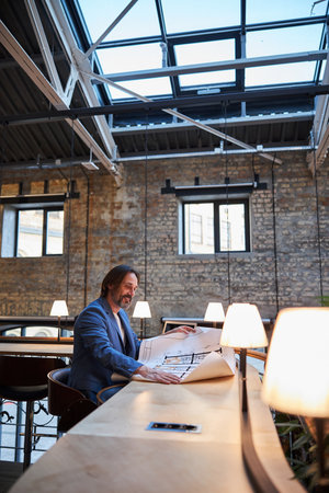 Successful businessman dealing with his paperwork at the tableの写真素材