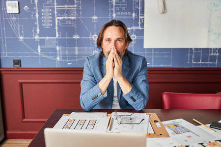 Overworked gentleman looking thoughtful in his officeの写真素材