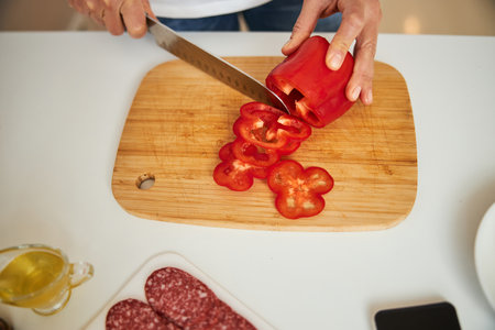 Slicing some veggies in the kitchen for delicious dinnerの写真素材