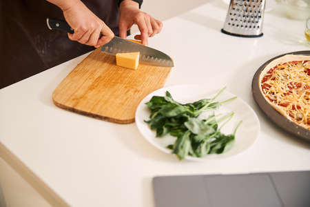 Cutting cheese while making pizza at home