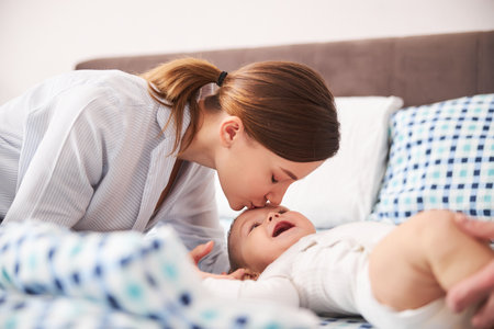 Young tender woman kissing her little kidの写真素材