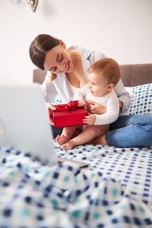 Cheerful female person giving present to her childの写真素材
