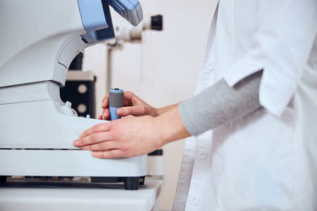 Focused image of experienced doctor looking lens in patient eyes with special machine