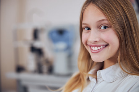 Pretty young lady in white shirt looking and posing at the photo camera in room indoorsの写真素材