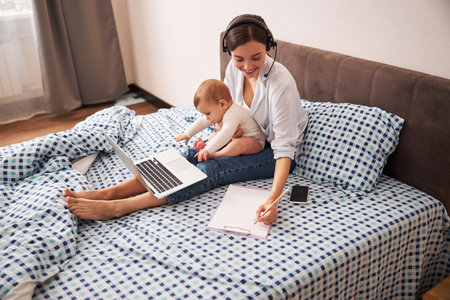 Cute brunette woman being at home with sonの写真素材