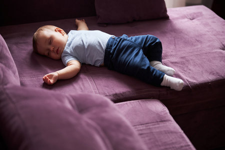 Tired little boy having rest after dinnerの写真素材