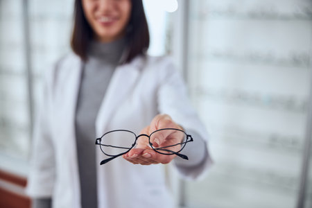 Focused image of stylish elegant eyeglasses in woman handの写真素材