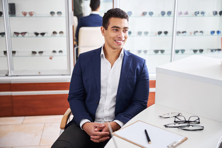 Joyous man sitting at the optometry office