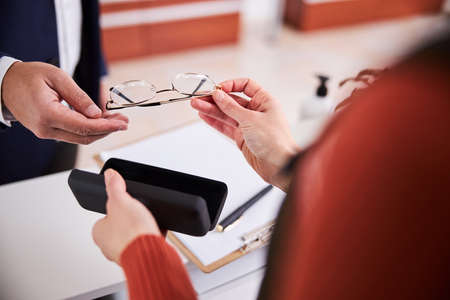 Male customer buying prescription glasses in an optical storeの写真素材
