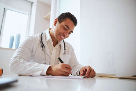 Professional Indian doctor working with documents in medicine officeの写真素材