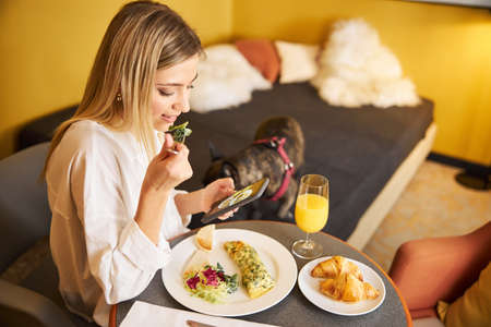 Woman taking a picture of her food at breakfastの写真素材