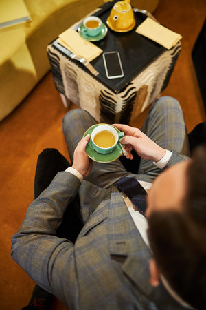 Elegant man in a fashionable suit drinking teaの写真素材