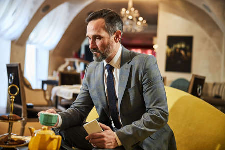Focused businessman having a quick break for tea