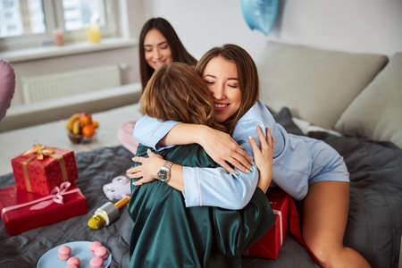 Two young female friends embracing each otherの写真素材