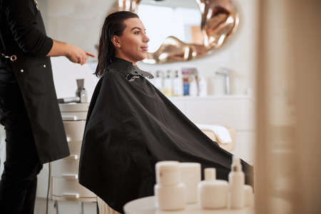 Dreamy female client being prepared for hairstylingの写真素材