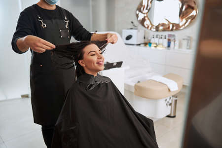 Stylist pulling the client hair to the sides