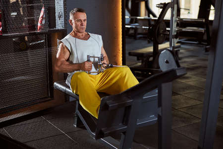 Reserved sporty man on a sitting rowing machine