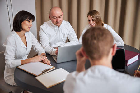 Healthcare personnel in uniforms holding a brief meeting