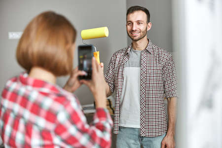 Joyous worker posing for the smartphone camera in the workplace