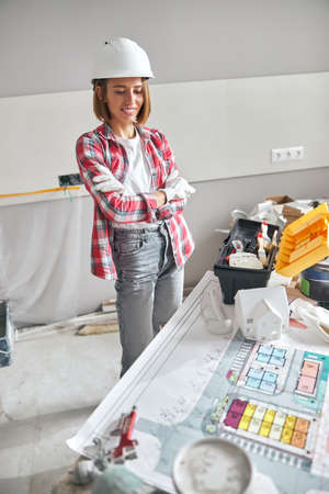 Pleased woman architect staring at a house plan