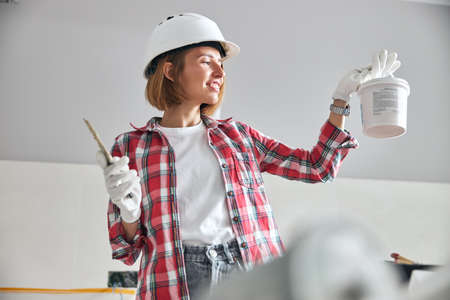 Painter in work gloves holding a paint bucketの写真素材