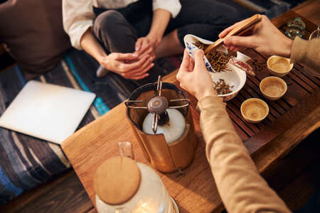 Young man making tea for clients in tea houseの写真素材