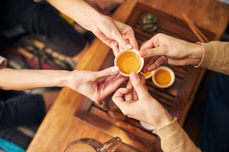 Young man giving cup of tea to woman in cafe