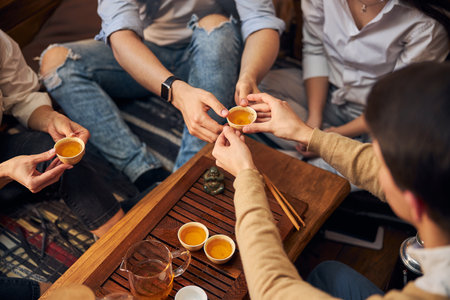 Young people having traditional tea ceremony in cafeの写真素材