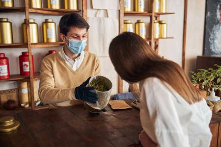Charming young woman making purchases in tea shopの写真素材