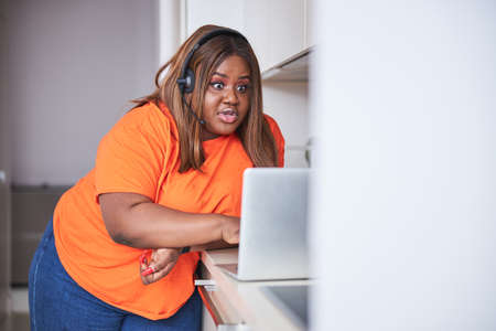 Shocked young woman looking at laptop screen