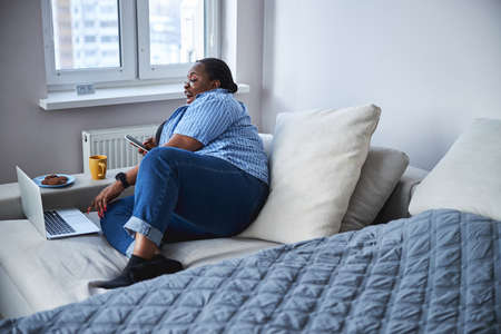 Shapely lady enjoying her tea and chill time at homeの写真素材