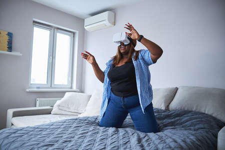 Curious lady trying virtual reality goggles at home
