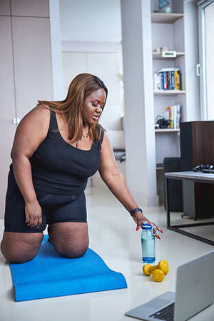 Admirable lady staying hydrated during her morning exercises