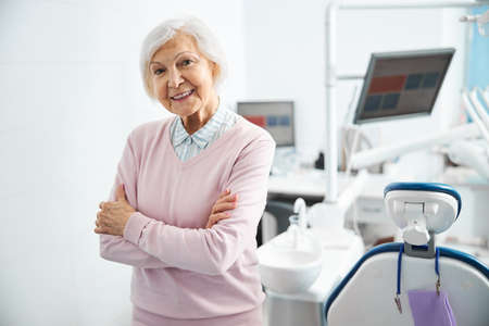 Retired woman folding arms at her chest in dental officeの写真素材
