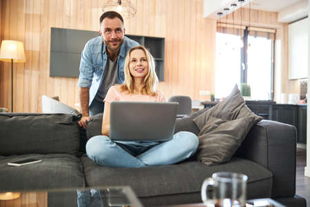 Beautiful couple using modern laptop at home