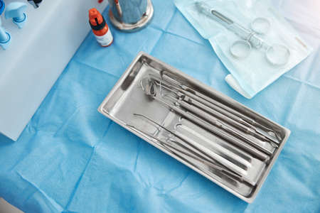 Dental tweezers lying in a metal trayの写真素材