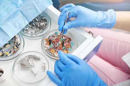 Dental surgeon lifting a single prophy cup from tray