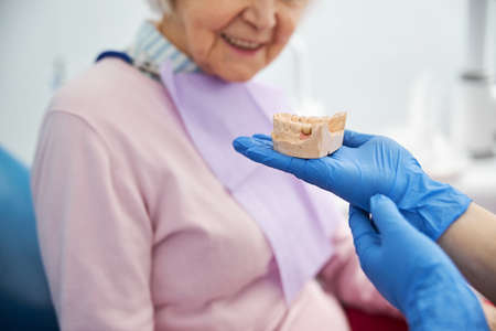 Dental cast inspected by an aged female