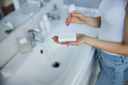 Young woman using antibacterial soap in bathroomの素材 [FY310166227176]