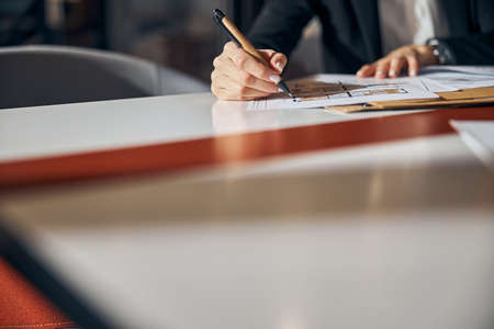 Engineer making corrections to a floor plan with a ball-point penの写真素材