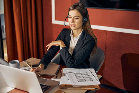 Concentrated woman architect looking at her laptop