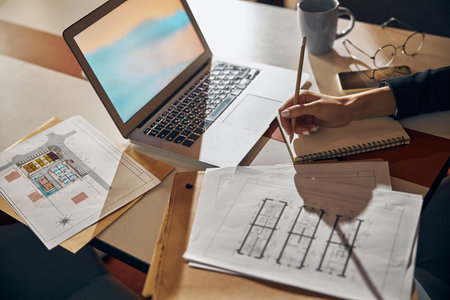 Engineer taking notes with a pencil at the deskの写真素材