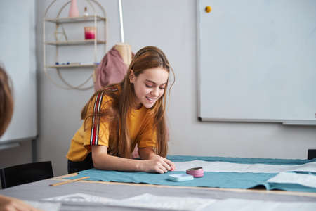 Cheerful female child working in sewing workshopの写真素材