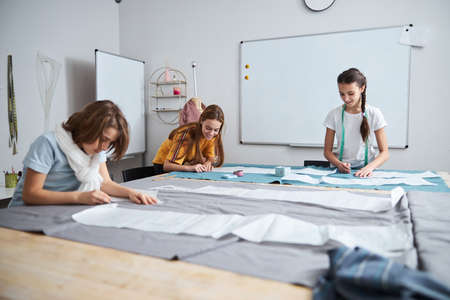 Joyful female kids working in sewing workshopの写真素材