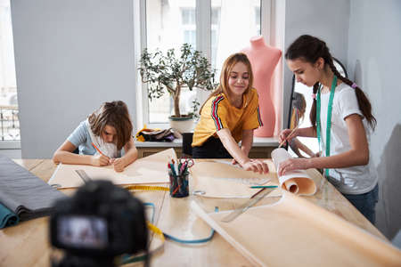 Cute female children making sewing patterns in workshopの写真素材