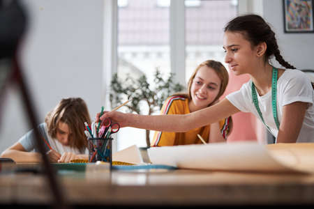 Cheerful cute girls working in sewing workshopの写真素材