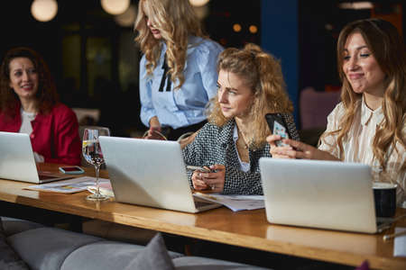 Beautiful women using laptops and smartphones at workの写真素材