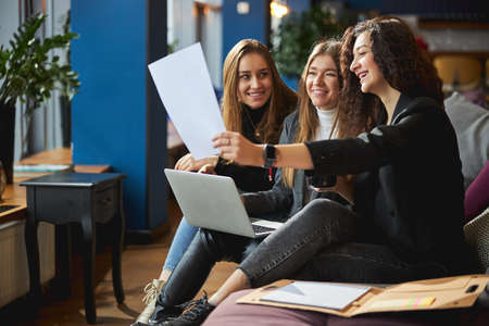 Cheerful creative mean discussing business project and using laptopの写真素材