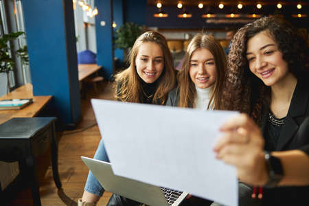 Cheerful business colleagues studying project sketch at workの写真素材