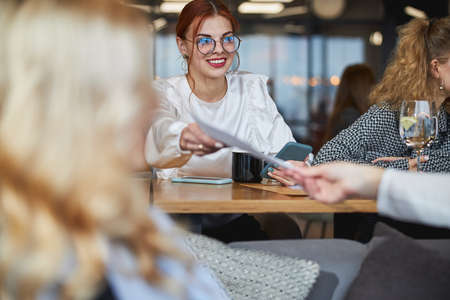 Charming young woman working on business project with colleaguesの写真素材